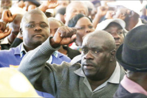 A police officer chanting a Zanu PF slogan during the war veterans’ meeting at Raylton Sports Club in Harare July 21, 2016 / Photo Credit: NewsDay