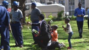 Sten Zvorwadza attempting to handover flowers to police. / Photo Credit: VOA Zimbabwe